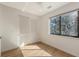 A cozy bedroom featuring natural light from the window, complemented by a closet and hardwood floors at 1778 10Th St, Sarasota, FL 34236