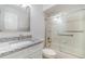 Well-lit bathroom showcasing a vanity with granite countertop and a bathtub with sliding glass doors at 3920 Bal Harbor Blvd # E1, Punta Gorda, FL 33950