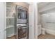 Convenient laundry area with stacked washer and dryer and a view of the adjacent bathroom at 3920 Bal Harbor Blvd # E1, Punta Gorda, FL 33950