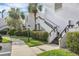 Well-maintained condo complex featuring lush landscaping, palm trees, and stairway access to upper units at 542 Lakeside Dr # 542, Bradenton, FL 34210