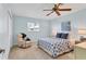 Cozy bedroom with leafy patterned comforter, ceiling fan, and neutral armchair at 7304 11Th W Ave, Bradenton, FL 34209