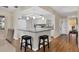 Bright, open kitchen with white cabinets, modern lighting, and a breakfast bar with seating at 7304 11Th W Ave, Bradenton, FL 34209