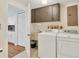 Well-equipped laundry room featuring modern washer and dryer, utility sink, and overhead storage at 7304 11Th W Ave, Bradenton, FL 34209