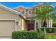 Home features a red front door, lovely landscaping, and a side-entry two-car garage at 1269 Western Pine Cir, Sarasota, FL 34240