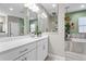 Modern bathroom with a double vanity, soaking tub, and glass-enclosed shower with neutral tones at 13891 Heartwood Way, Parrish, FL 34219