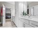 Bright bathroom features a modern vanity, cabinets, large mirror, and open doorway to another bedroom at 13891 Heartwood Way, Parrish, FL 34219