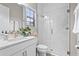 Bright bathroom featuring a glass door shower, a large mirror, white cabinets and a white toilet at 13891 Heartwood Way, Parrish, FL 34219