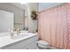 Bright bathroom with a modern vanity, toilet, and a shower with patterned curtain at 13891 Heartwood Way, Parrish, FL 34219