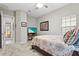 Bedroom featuring a TV, patterned bedding, carpeted floors and natural lighting from a large window at 13891 Heartwood Way, Parrish, FL 34219