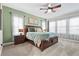 Well-lit bedroom featuring a decorative ceiling fan, wide windows, and a plush bed at 13891 Heartwood Way, Parrish, FL 34219