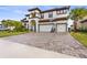 Two-story home featuring an arched entryway, two-car garage, paver driveway and tile roof at 13891 Heartwood Way, Parrish, FL 34219