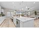 Bright and airy kitchen with stainless steel appliances, a central island, and views into the living area at 13891 Heartwood Way, Parrish, FL 34219