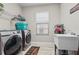 Convenient laundry room equipped with modern washer, dryer, sink, and ample storage space at 13891 Heartwood Way, Parrish, FL 34219