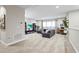 Spacious, carpeted living room with a gray sectional sofa, TV, bookshelves and natural light from windows at 13891 Heartwood Way, Parrish, FL 34219