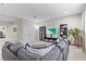 Carpeted living room featuring gray sectional sofa, TV with storage, two windows, and a decorative plant at 13891 Heartwood Way, Parrish, FL 34219