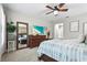 Comfortable main bedroom with a dresser, mirror, ceiling fan, carpeted floors, and a serene view at 13891 Heartwood Way, Parrish, FL 34219
