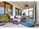 Relaxing covered patio featuring comfortable seating, a ceiling fan, and a view of the landscaped backyard at 13891 Heartwood Way, Parrish, FL 34219