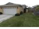 Exterior view of the home with an attached two-car garage and lush lawn at 9400 Ridge Rd, Seminole, FL 33772