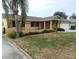 Single-Gathering home boasts manicured landscaping, iron fencing, and an attached two-car garage at 9400 Ridge Rd, Seminole, FL 33772