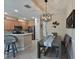 Charming dining area open to the kitchen with a modern chandelier, table with seating, and barstools at 9606 Sea Turtle Ter # 101, Bradenton, FL 34212