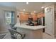 Well-lit kitchen showcasing stainless steel appliances, light wood cabinetry, breakfast bar, and a window at 9606 Sea Turtle Ter # 101, Bradenton, FL 34212