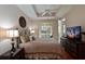 Bright main bedroom featuring a ceiling fan, hardwood floors, and sliding glass doors to the lanai at 9606 Sea Turtle Ter # 101, Bradenton, FL 34212