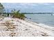 Tranquil beach scene with gentle waves, sandy shore, and distant views of waterfront properties at 101 S Gulfstream Ave # 10E, Sarasota, FL 34236