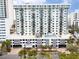 External shot of a tall condominium featuring balconies and a pool deck on the top parking garage level at 101 S Gulfstream Ave # 10E, Sarasota, FL 34236