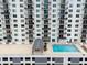 Condominium rooftop pool surrounded by lounge chairs and seating with city views at 101 S Gulfstream Ave # 10E, Sarasota, FL 34236