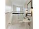 Bright bathroom featuring a classic pedestal sink, tiled shower, and black and white patterned floors at 1825 Bayshore Dr, Terra Ceia, FL 34250