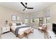 Well-lit bedroom with hardwood floors, natural light, a ceiling fan and calming decor at 1825 Bayshore Dr, Terra Ceia, FL 34250