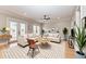 Bright living room with two sofas, neutral decor, and natural light from the double doors at 1825 Bayshore Dr, Terra Ceia, FL 34250