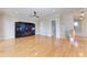 Open living room with hardwood floors, ceiling fan, entertainment center, and staircase at 1825 Bayshore Dr, Terra Ceia, FL 34250