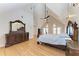 A spacious main bedroom showcasing wood floors, high vaulted ceilings, ceiling fans, and french doors at 1825 Bayshore Dr, Terra Ceia, FL 34250
