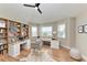 Home office with custom built-in desks, shelving, hardwood floors, and natural light from windows at 1825 Bayshore Dr, Terra Ceia, FL 34250