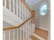 Traditional staircase with white risers, hardwood steps, and a wood railing at 1825 Bayshore Dr, Terra Ceia, FL 34250