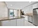 Bright kitchen with white cabinets, stainless steel appliances, and view to the Lanai at 304 Pine Run Dr, Osprey, FL 34229