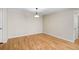 Bright, empty living room with hardwood floors and neutral paint, illuminated by a pendant light at 304 Pine Run Dr, Osprey, FL 34229