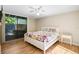 Comfortable bedroom with a large window, wood floors, and a ceiling fan to maintain a refreshing atmosphere at 304 Pine Run Dr, Osprey, FL 34229