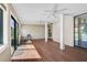 Open sun room with multiple ceiling fans, large windows, and wood-look flooring at 304 Pine Run Dr, Osprey, FL 34229