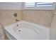 Close up of a clean white bath tub with matching neutral tile surround and plantation shutters at 4326 Silo Port Ct, Lakewood Ranch, FL 34211
