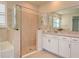 Bathroom with a glass enclosed shower and soaker tub, white cabinets, and neutral tile at 4326 Silo Port Ct, Lakewood Ranch, FL 34211