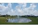 Community pond with water feature, trees and blue sky with fluffy white clouds at 4326 Silo Port Ct, Lakewood Ranch, FL 34211
