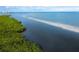 Scenic aerial shot of the coast, showcasing lush green vegetation and clear blue waters at 560 Harbor Point Rd, Longboat Key, FL 34228