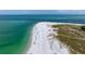 Panoramic aerial view of a crowded sandy beach meeting turquoise ocean water at 727 Holly Rd, Anna Maria, FL 34216