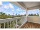 Balcony with wood flooring and views of the wooded neighborhood in the distance at 727 Holly Rd, Anna Maria, FL 34216
