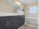 Modern bathroom featuring a soaking tub, double vanity, and bright natural light at 727 Holly Rd, Anna Maria, FL 34216