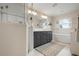 Well-lit bathroom featuring a dual sink vanity and a luxurious soaking tub beneath the window at 727 Holly Rd, Anna Maria, FL 34216