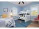 Well lit bedroom with wood flooring, bunk beds, single bed, and window with plantation shutters at 727 Holly Rd, Anna Maria, FL 34216