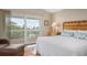 Bright bedroom featuring a large bed, bamboo headboard, and sliding glass doors to a balcony at 727 Holly Rd, Anna Maria, FL 34216